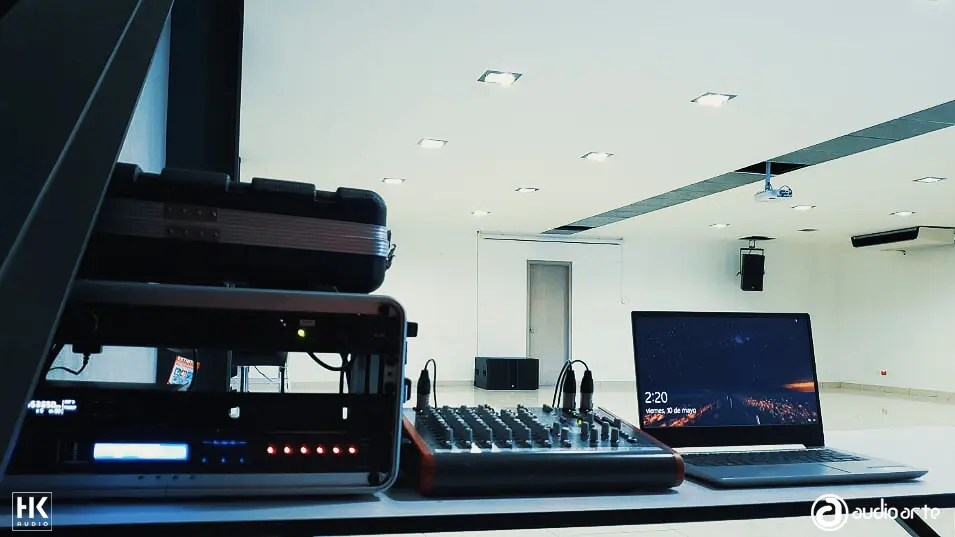 Auditorio blanco, con parlante y consola de sonido